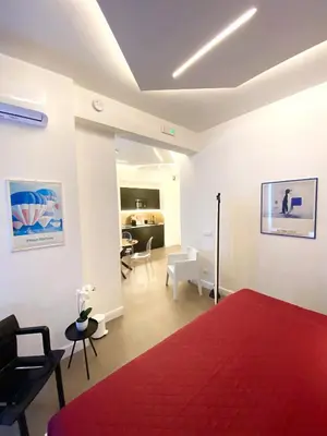 a bedroom with a red bed and a living room at La Maison, vicino al Colosseo! in Rome
