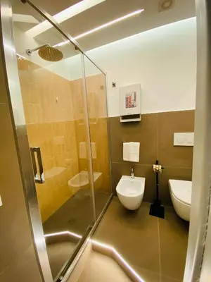 a bathroom with a glass shower and a toilet at La Maison, vicino al Colosseo! in Rome