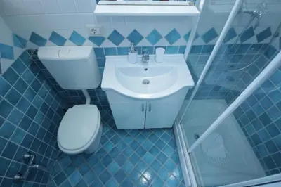 a blue tiled bathroom with a toilet and a sink at Marco Aurelio in Rome