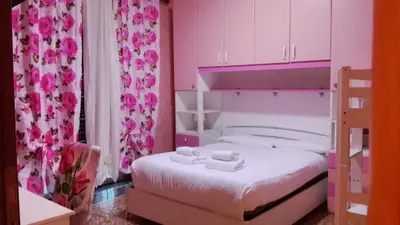a pink bedroom with a bed with two towels at Marco Aurelio in Rome