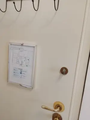 a white door with a plan on the wall at Casa Bella B&B 2 Unità - Una con bagno privato oppure camera con bagno condiviso in Rome