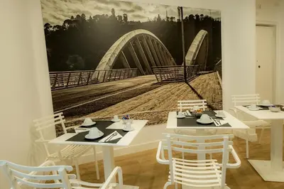 a dining room with two tables and a painting of a bridge at Suite Pinturicchio in Rome