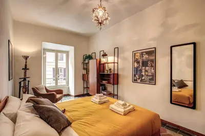 a bedroom with a bed and a couch and a mirror at Trastevere San Cosimato vintage in Rome