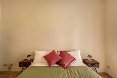 a bedroom with a bed with red pillows on it at Trastevere San Cosimato vintage in Rome