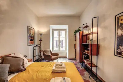 a bedroom with a bed with a yellow blanket at Trastevere San Cosimato vintage in Rome