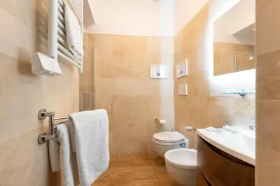 a bathroom with a bed and a toilet in a room at Manfredi House San Pietro in Rome