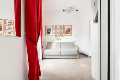 a living room with a couch and a red curtain at Manfredi House San Pietro in Rome
