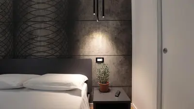 a bedroom with a bed and a plant on a table at Suite Inn Rome in Rome