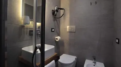 a bathroom with a shower and a toilet and a sink at Suite Inn Rome in Rome