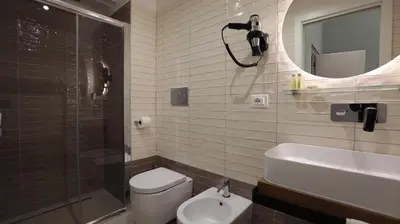 a bathroom with a shower and a toilet and a sink at Suite Inn Rome in Rome