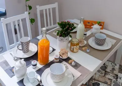 a table with plates and cups and bottles on it at ISABEL Guest House in Rome