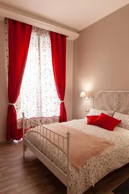 a bedroom with a bed with red curtains and a window at ISABEL Guest House in Rome