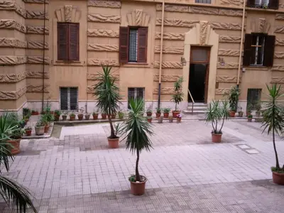 a courtyard with potted plants in front of a building at ISABEL Guest House in Rome
