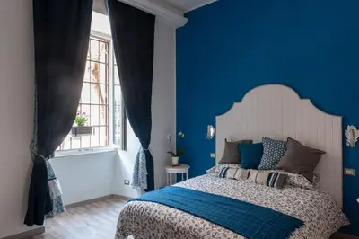 a blue bedroom with a bed and a window at ISABEL Guest House in Rome