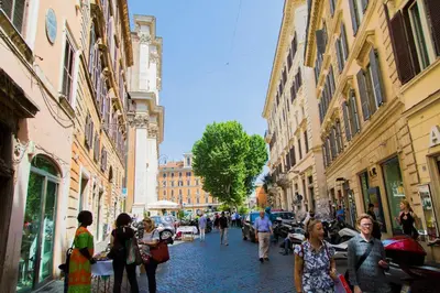 a group of people walking down a street with buildings at H-Aviva Giubbonari Apartment in Rome