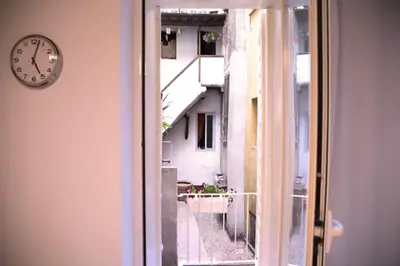 an open window with a clock next to a building at H-Aviva Giubbonari Apartment in Rome