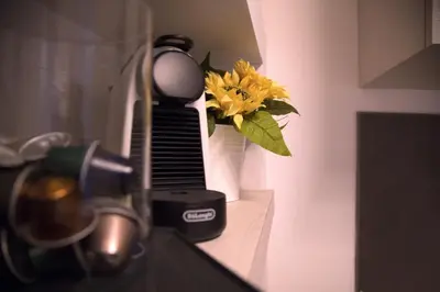 a vase with a yellow flower sitting on a counter at H-Aviva Giubbonari Apartment in Rome