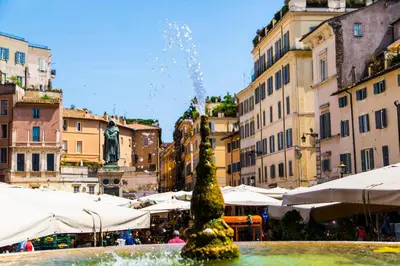 a fountain in the middle of a city with buildings at H-Aviva Giubbonari Apartment in Rome