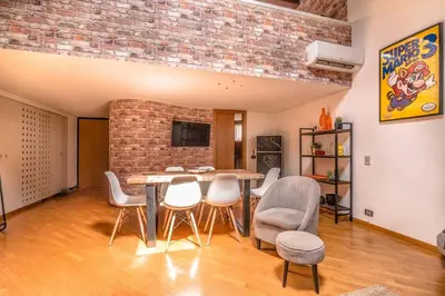 a dining room with a table and chairs and a brick wall at Loft 60 - EXCLUSIVE LOFT ROME CITY CENTER in Rome