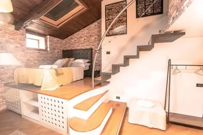 a loft bedroom with two beds and a staircase at Loft 60 - EXCLUSIVE LOFT ROME CITY CENTER in Rome