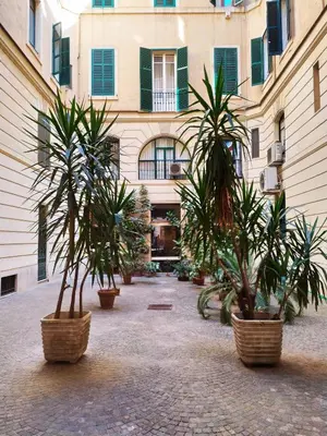 a courtyard with three potted plants in front of a building at Loft 60 - EXCLUSIVE LOFT ROME CITY CENTER in Rome