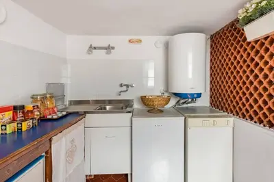 a kitchen with white cabinets and a sink at Trastevere Alley Apartment in Rome
