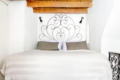 a bedroom with a white bed with a metal headboard at Trastevere Alley Apartment in Rome
