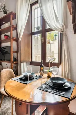 a wooden table with plates and glasses and a window at Trastevere Alley Apartment in Rome