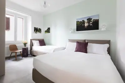 a bedroom with a large white bed and a couch at ROMAC Villa Borghese with 3 bedrooms near Via Veneto in Rome