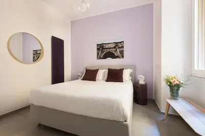 a white bedroom with a large bed and a mirror at ROMAC Villa Borghese with 3 bedrooms near Via Veneto in Rome