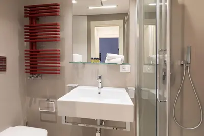 a bathroom with a white sink and a shower at ROMAC Villa Borghese with 3 bedrooms near Via Veneto in Rome