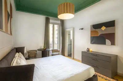 a bedroom with a bed and a couch and a table at ROMAC Mazzini with 5 bedrooms near the Vatican in Rome