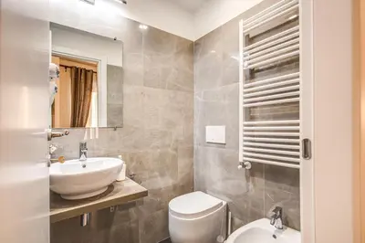 a bathroom with a sink and a toilet and a mirror at River Luxury Suites in Rome