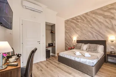 a bedroom with a bed and a table and a desk at River Luxury Suites in Rome
