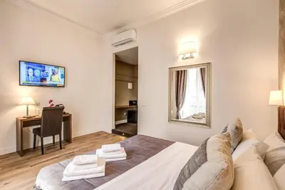 a bedroom with a bed and a desk and a table at River Luxury Suites in Rome