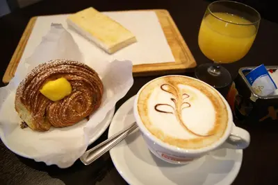 a cup of coffee and a pastry on a table at River Luxury Suites in Rome