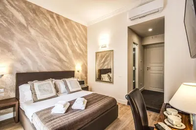 a bedroom with a bed and a desk with a chair at River Luxury Suites in Rome