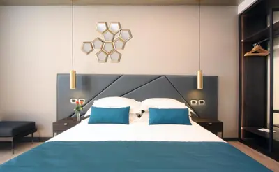 a bedroom with a large bed with two blue pillows at The Hive Hotel in Rome