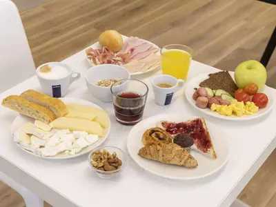 a white table topped with plates of food and drinks at B&B Hotel Roma Trastevere in Rome