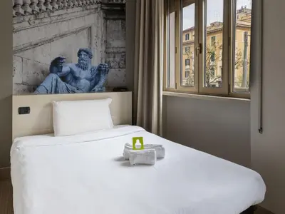 a bed in a room with a statue in the background at B&B Hotel Roma Trastevere in Rome