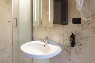 a bathroom with a white sink and a phone at B&B Hotel Roma Trastevere in Rome