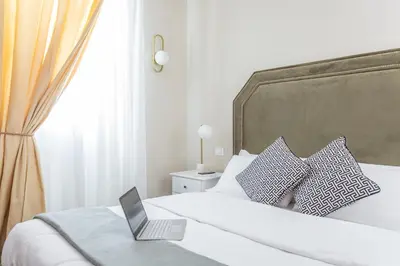a laptop computer sitting on top of a bed at Daplace - La Mongolfiera Rooms in Navona in Rome