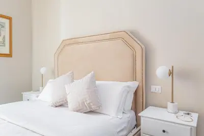 a bedroom with a white bed with white pillows at Daplace - La Mongolfiera Rooms in Navona in Rome