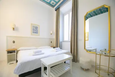 a bedroom with a white bed and a mirror at Caffe' e Cuscino in Rome