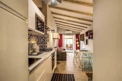 a kitchen with white counters and a living room at Attic with Terrace by Trevi Fountain in Rome
