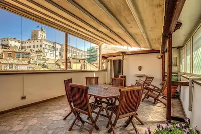 a patio with a table and chairs on a balcony at Attic with Terrace by Trevi Fountain in Rome