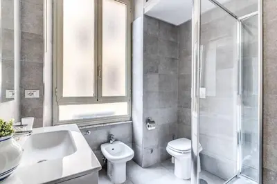 a bathroom with a sink and a toilet and a shower at Lovely renovated flat by Vatican in Rome