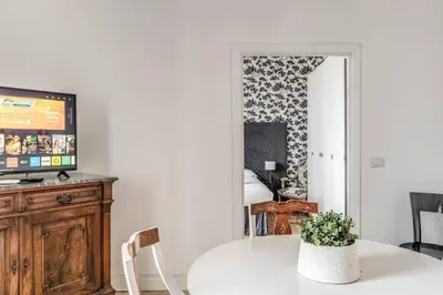 a living room with a white table and a tv at Lovely renovated flat by Vatican in Rome