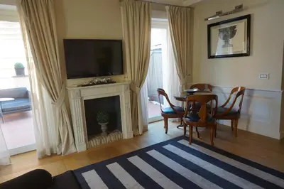 a living room with a table and a television on a fireplace at Trevi Palace Luxury Inn in Rome