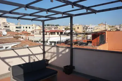 a chair on a balcony with a view of a city at Trevi Palace Luxury Inn in Rome